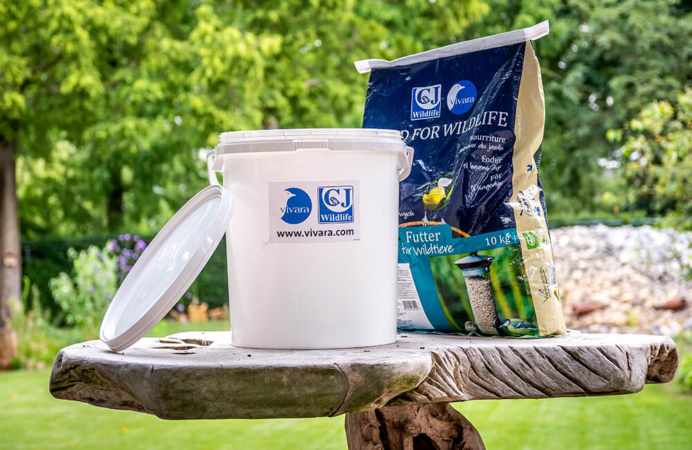 Förvaringshink bredvid en stor påse med frön.